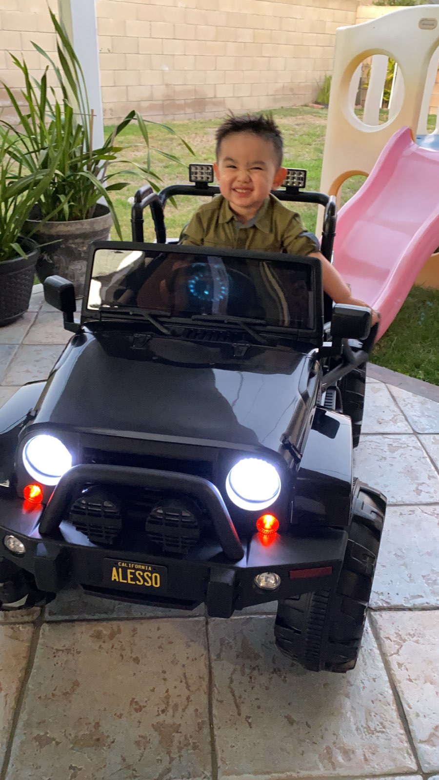 Child smiling in a black toy jeep featuring a Personalized California 2
